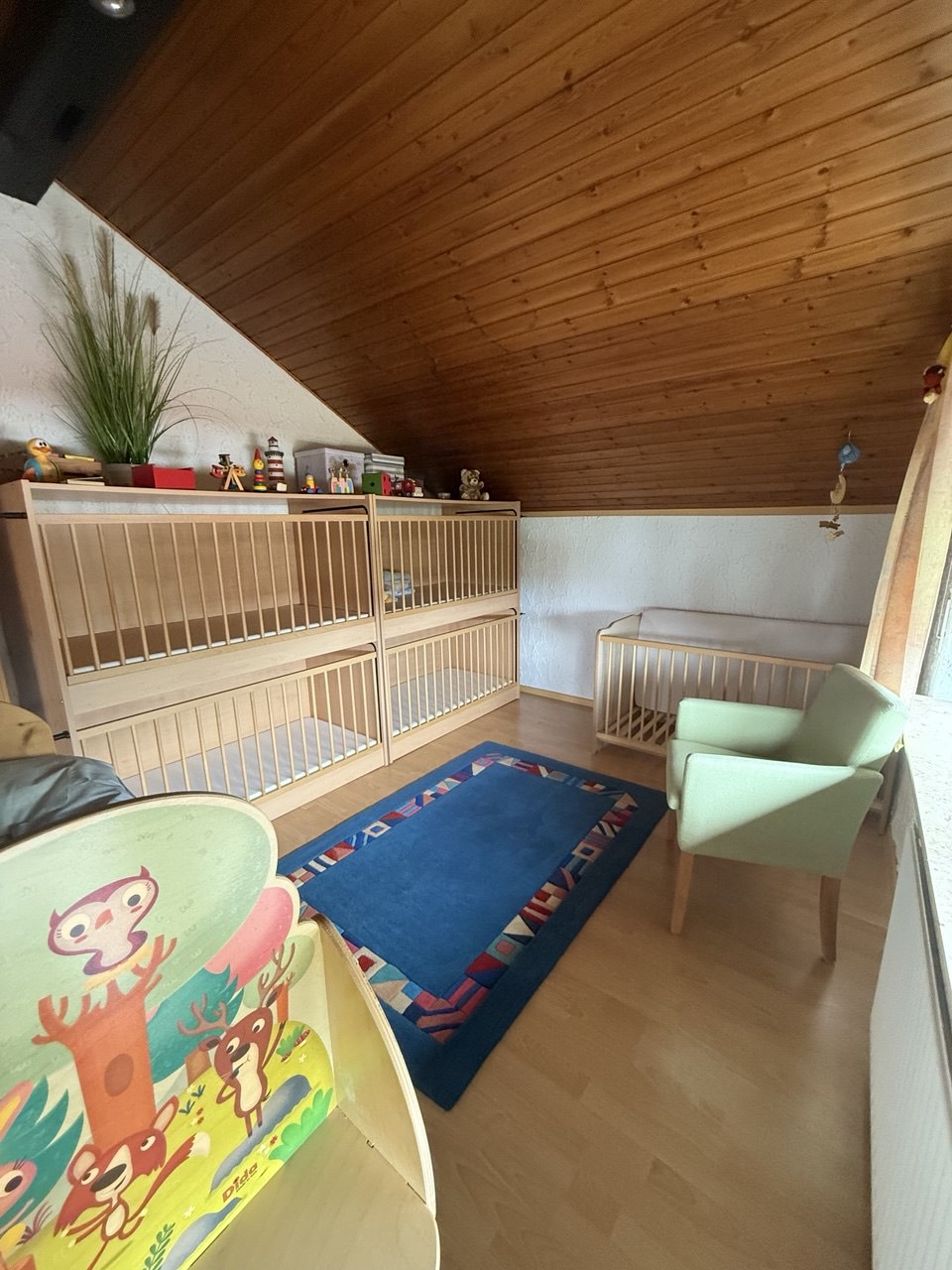 Schlafbereich mit Gitterbetten und Kindersessel