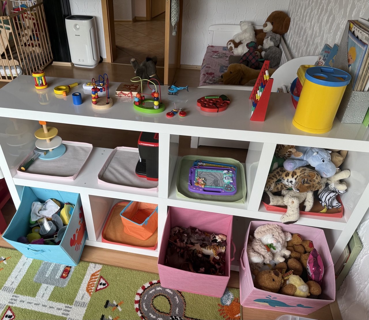 Spielregal mit Kuscheltieren und Lernspielzeug